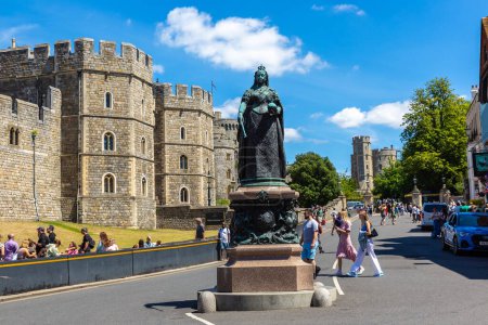 Foto de WINDSOR, Reino Unido - 19 de junio de 2022: Estatua de la Reina Victoria frente al Castillo de Windsor en Windsor en un soleado día de verano, Reino Unido - Imagen libre de derechos