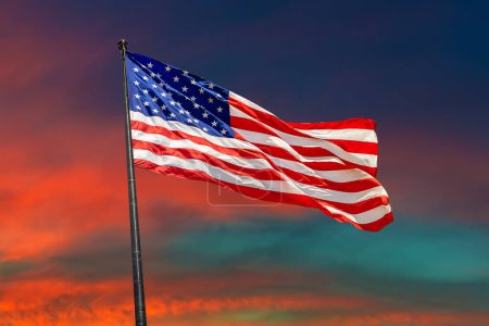 Foto de Bandera de EE.UU. ondeando contra el cielo del atardecer con hermosa nube - Imagen libre de derechos