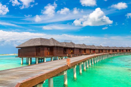 Téléchargez les photos : Villas d'eau (Bungalows) et pont en bois à la plage tropicale aux Maldives le jour de l'été - en image libre de droit