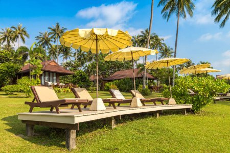 Téléchargez les photos : Transats et parasol de plage au Luxury tropical resort par une journée ensoleillée - en image libre de droit