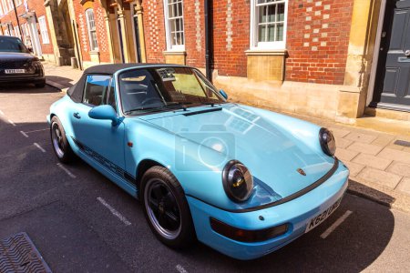 Photo for WINDSOR, UK - JUNE 19, 2022: Porsche 911 Carrera 4 Cabriolet in Blue in a sunny day in Windsor, UK - Royalty Free Image