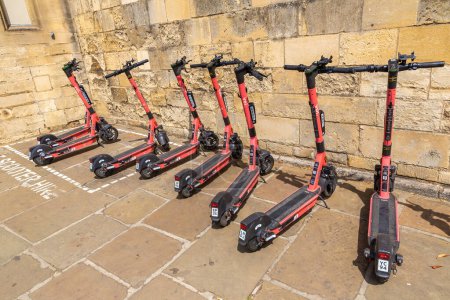 Foto de OXFORD, Reino Unido - 11 de junio de 2022: Alquiler de scooters eléctricos compartidos por la empresa VOI en una calle de Oxford en un día de verano, Reino Unido - Imagen libre de derechos