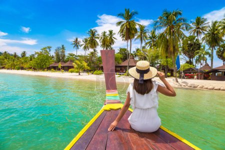 Téléchargez les photos : Joyeux voyageur femme relaxant sur le bateau près de l'île tropicale en Thaïlande - en image libre de droit