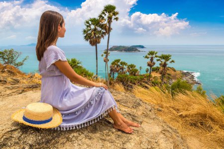 Photo for Woman traveler wearing blue dress and straw hat at   Phromthep Cape at Phuket in Thailand in a summer day - Royalty Free Image