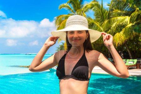 Photo for Sexy beautiful woman at luxury tropical swimming pool at the beach in a sunny summer day - Royalty Free Image