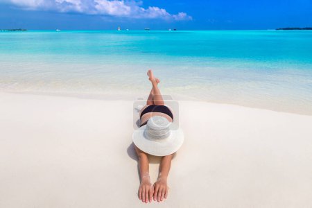 Téléchargez les photos : Sexy belle femme posée à la plage tropicale de luxe dans une journée d'été ensoleillée - en image libre de droit