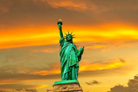 Foto de Estatua de la Libertad contra el cielo al atardecer con hermoso fondo nuboso en Nueva York, NY, EE.UU. - Imagen libre de derechos