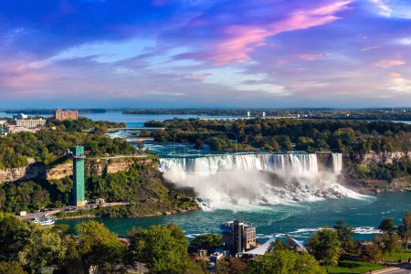 Téléchargez les photos : Vue aérienne panoramique du côté canadien des chutes Niagara, des chutes American et de la tour d'observation au coucher du soleil à Niagara Falls, Ontario, Canada - en image libre de droit