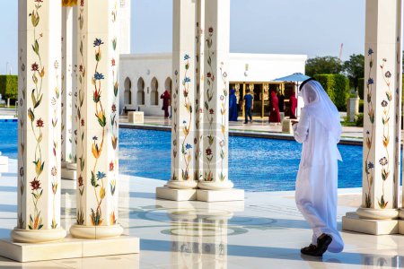 Téléchargez les photos : Un Arabe porte des vêtements arabes à la Grande Mosquée Cheikh Zayed à Abu Dhabi, Émirats Arabes Unis - en image libre de droit