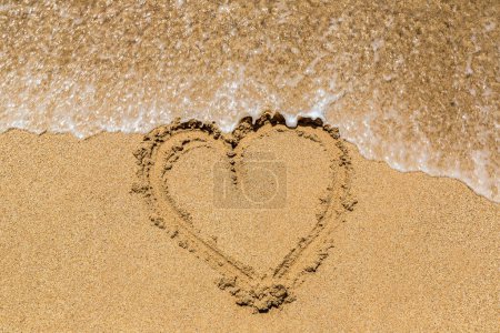 Téléchargez les photos : Symbole de coeur écrit dans un sable sur une plage tropicale - en image libre de droit