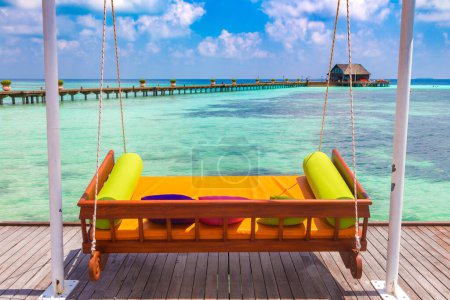 Téléchargez les photos : Lit balançoire dans une station balnéaire tropicale de luxe par une journée d'été ensoleillée - en image libre de droit