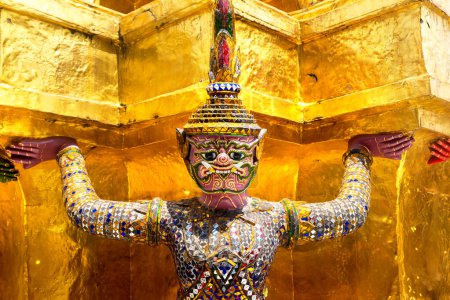 Foto de Estatuas del Guardián del Demonio están apoyando la estupa Chedi dorada en el templo de Wat Phra Kaew en un día soleado - Imagen libre de derechos