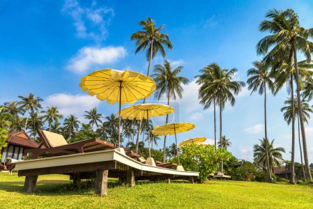 Foto de Tumbonas y sombrilla de playa en complejo tropical de lujo en un día soleado - Imagen libre de derechos