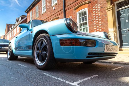 Téléchargez les photos : WINDSOR, Royaume-Uni - 19 JUIN 2022 : Porsche 911 Carrera 4 Cabriolet en bleu par une journée ensoleillée à Windsor, Royaume-Uni - en image libre de droit