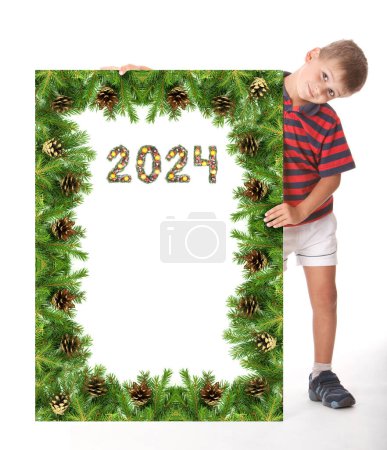 Photo for Boy  is holding a christmas poster and 2024 number made by christmas tree branches isolated on white background - Royalty Free Image