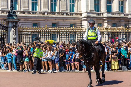 Foto de LONDRES, Reino Unido - 17 de junio de 2022: Policía montada metropolitana patrullando el cambio de guardia frente al Palacio de Buckingham en Londres en un soleado día de verano, Reino Unido - Imagen libre de derechos
