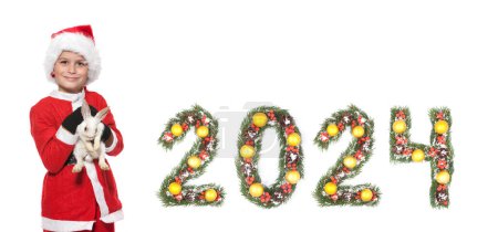 Téléchargez les photos : Nouvel an chinois. Garçon tenant un lapin de Noël et 2024 nombre fait par branches d'arbre de Noël isolé sur fond blanc - en image libre de droit