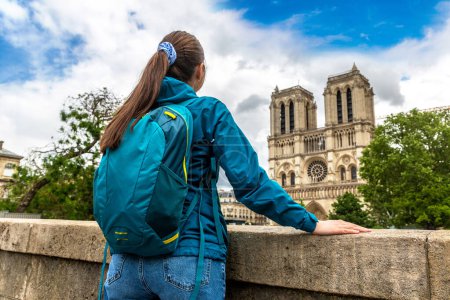 Foto de Mujer viajera en Notre Dame de Paris es uno de los símbolos más famosos de París en un día de verano, Francia - Imagen libre de derechos