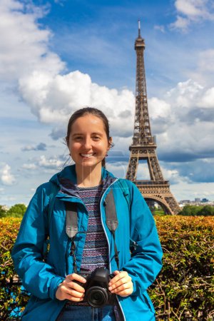 Photo for Woman traveler at Eiffel Tower in Paris in a sunny summer day, France - Royalty Free Image