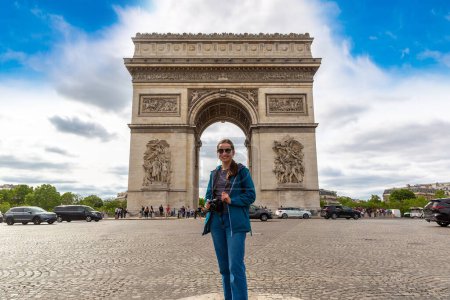 Photo for Woman traveler at Paris Arc de Triomphe (Triumphal Arch) in Paris in a summer day, France - Royalty Free Image