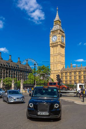 Foto de LONDRES, REINO UNIDO - 26 de junio de 2022: Taxi y Big Ben en Londres en un día soleado, Inglaterra, Reino Unido - Imagen libre de derechos