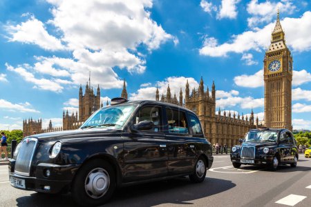 Foto de LONDRES, EL REINO UNIDO - 26 DE JUNIO DE 2022: Símbolos de Londres - Big Ben, Palacio de Westminster y taxi de Londres (Black Cab) en el Puente de Westminster en Londres, Inglaterra, Reino Unido - Imagen libre de derechos