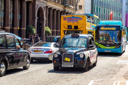 Photo for LIVERPOOL, UK - AUGUST 16, 2023: Taxi car and a bus - Public transport in a sunny day in Liverpool, United Kingdom - Royalty Free Image