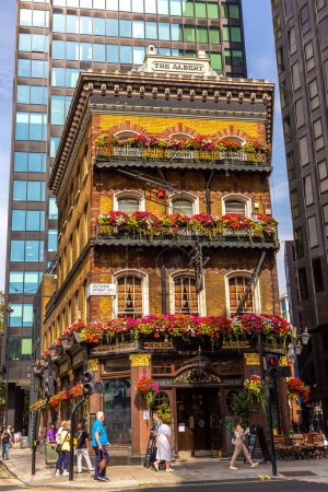 Foto de LONDRES, Reino Unido - 8 de septiembre de 2023: El antiguo pub victoriano Albert rodeado de rascacielos en Londres en un día soleado, Inglaterra, Reino Unido - Imagen libre de derechos