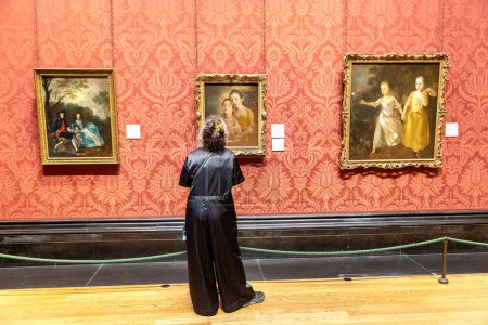 Téléchargez les photos : LONDRES, RU - 8 SEPTEMBRE 2023 : Visiteur regarde les peintures à l'huile accrochées à la National Gallery à Trafalgar Square à Londres, RU - en image libre de droit