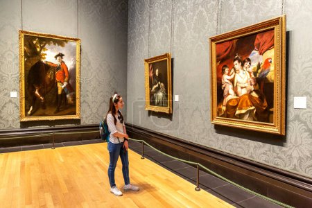 Téléchargez les photos : LONDRES, RU - 8 SEPTEMBRE 2023 : Visiteur regarde les peintures à l'huile accrochées à la National Gallery à Trafalgar Square à Londres, RU - en image libre de droit