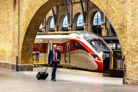 Foto de LONDRES, Reino Unido - 26 de septiembre de 2023: Un hombre con una maleta camina en la estación de tren de King 's Cross en Londres, Inglaterra, Reino Unido - Imagen libre de derechos