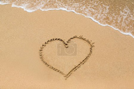 Símbolo del corazón escrito en una playa tropical