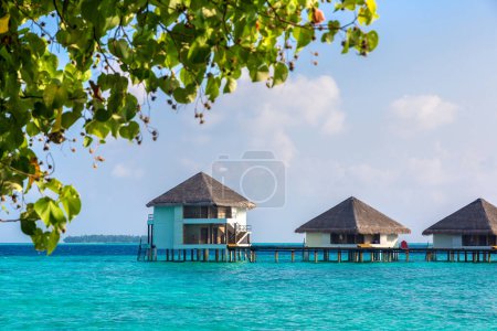 Photo for Water Villas (Bungalows) and wooden bridge at Tropical beach in the Maldives at summer day - Royalty Free Image