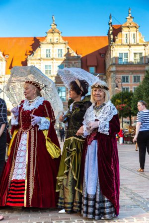 Foto de GDANSK, POLONIA - 7 DE SEPTIEMBRE DE 2022: Grupo de mujeres vestidas con vestimenta popular tradicional nacional polaca en un hermoso casco antiguo de Gdansk, Polonia - Imagen libre de derechos