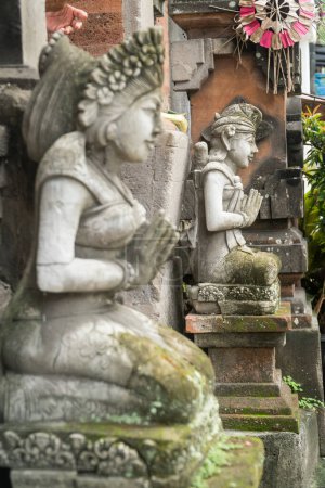 Foto de Estatua de piedra con las manos en una oración en la entrada del templo en Bali, Indonesia. Concepto de símbolos de sacrificio espiritual - Imagen libre de derechos