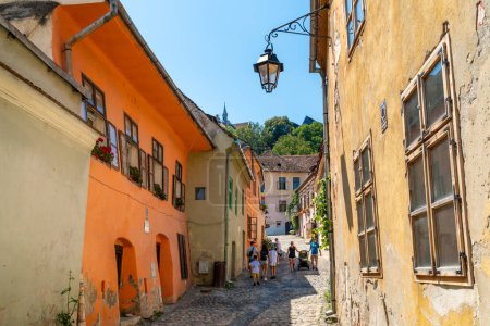Photo for SIGHISOARA, ROMANIA - august 8, 2019:  People walking old  medieval streets in  Sighisoara, Romania,  in well-preserved old town, listed by UNESCO as a World Heritage Site - Royalty Free Image