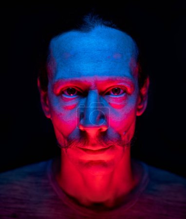 Foto de Retrato de un hombre mostrando la lengua en la luz azul-roja, foto de arte emocional - Imagen libre de derechos