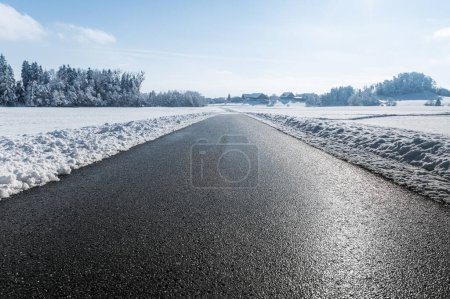Téléchargez les photos : Parfait belle route asphaltée rurale à travers les champs enneigés, journée ensoleillée - en image libre de droit
