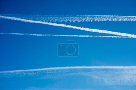 Téléchargez les photos : Les traînées de vapeur du contraileur sont des nuages en forme de ligne produits par les gaz d'échappement des moteurs d'aéronef ou les changements de pression atmosphérique, généralement à des altitudes de croisière de plusieurs milles au-dessus de la surface de la Terre. - en image libre de droit