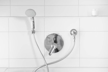 Foto de Grifo y cabezal de ducha en un baño con azulejos blancos - Imagen libre de derechos