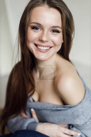 Foto de Joven mujer sonriente en el interior en ropa acogedora. Foto de alta calidad - Imagen libre de derechos