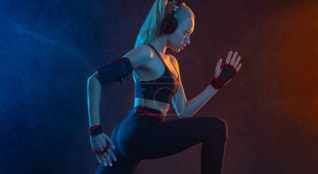 Foto de Fuerte atlética mujer en forma de fondo negro que lleva en la ropa deportiva. Fitness y motivación deportiva - Imagen libre de derechos