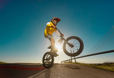 Téléchargez les photos : Un adolescent BMX Racing Rider effectue des tours dans un skate park sur une piste de pompe - en image libre de droit
