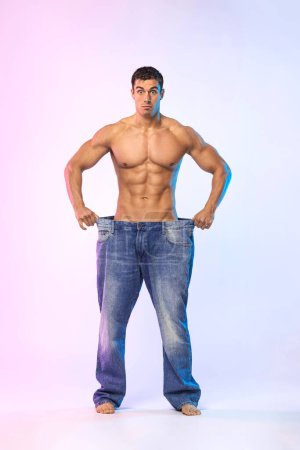 Photo for Man showing how much weight he lost. Fat to fit concept. Fitness flyer. - Royalty Free Image