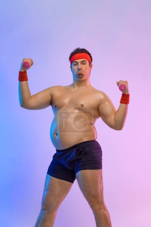 Photo for Fat man with burger and dumbbell. Not sporty men eating hamburger isolated on pink background - Royalty Free Image