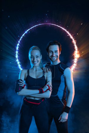 Téléchargez les photos : Download photo for advertising a fitness club in social networks. Fitness Influencers. Fitness couple at home. Cover for sport motivation music. Fit man and woman at the gym on black background - en image libre de droit