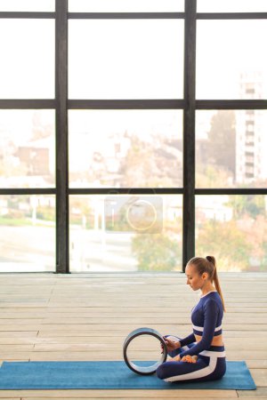 Foto de Download photo for yoga classes ads. Yoga asana Indoor. Sports recreation. Beautiful young woman in yoga pose. Individual sports. - Imagen libre de derechos