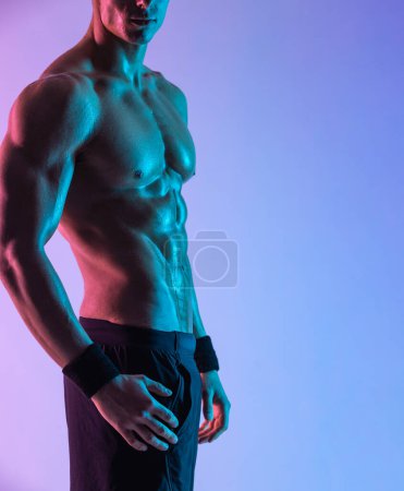 Fotografía corporal cerrada. Hombre atleta aislado sobre fondo rosa. Gimnasio entrenamiento de cuerpo completo. El atleta musculoso del hombre en gimnasio de la aptitud tiene entrenamiento havy. Entrenador deportivo en entrenamiento. Motivación física