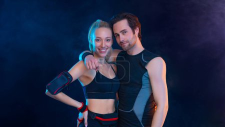 Photo for Download photo for advertising a fitness club in social networks. Fitness Influencers. Fitness couple at home. Cover for sport motivation music. Fit man and woman at the gym on black background. - Royalty Free Image