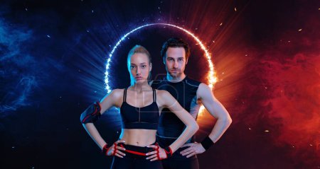 Téléchargez les photos : Download photo for advertising a fitness club in social networks. Fitness Influencers. Fitness couple at home. Cover for sport motivation music. Fit man and woman at the gym on black background - en image libre de droit